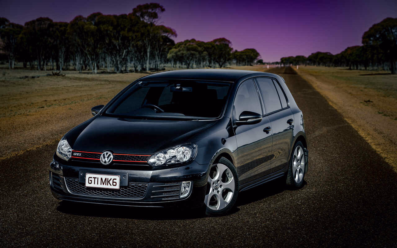 Czarny hatchback Volkswagen Golf stojący na drodze